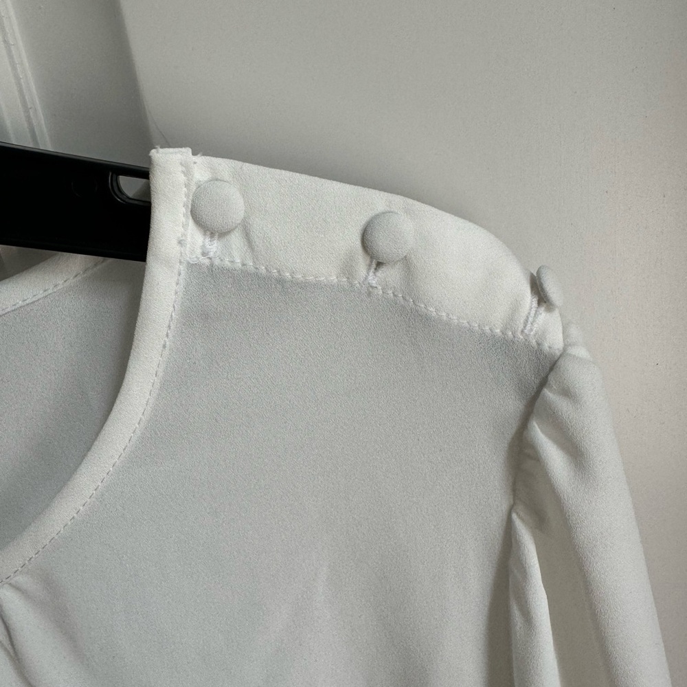 J.Crew cream blouse with covered button shoulder and flutter cuffs.